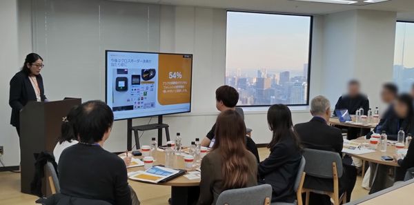 Sachi presenting in front of audience in office