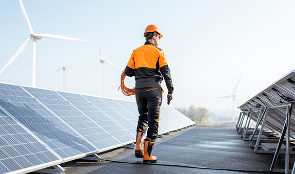 Man Wearing An Orange Helmet Working Nearby Solar Panels